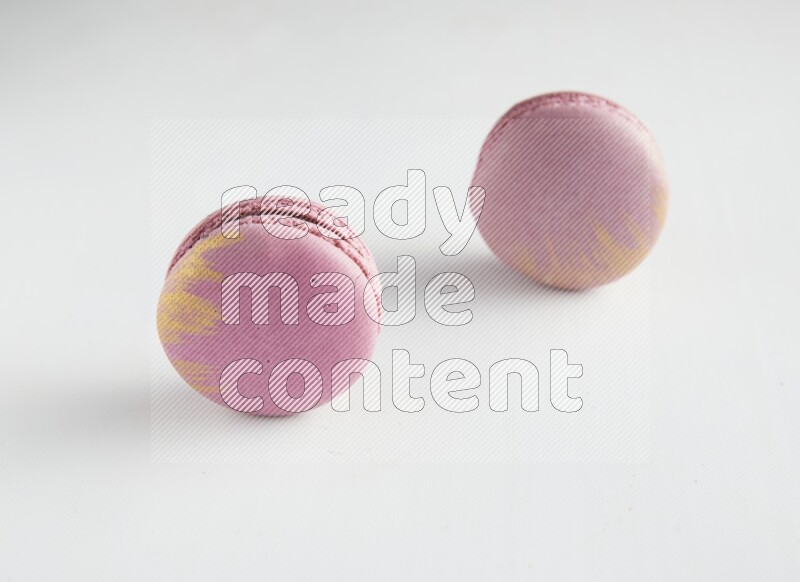 45º Shot of two Purple Strawberry macarons on white background