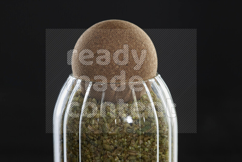 Freekeh in a glass jar on black background