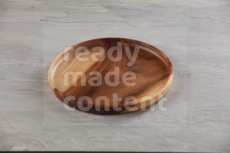 brown wood round plate on grey textured countertop