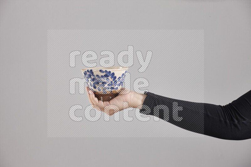 A woman in black abaya holding different pottery essentials in different positions