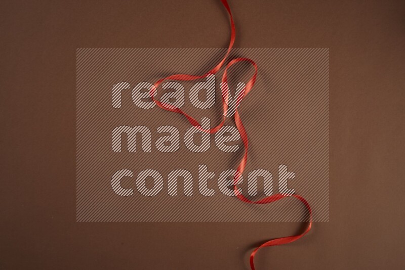 مجموعة من أدوات الخياطة والتفصيل حمراء اللون على خلفية بنية