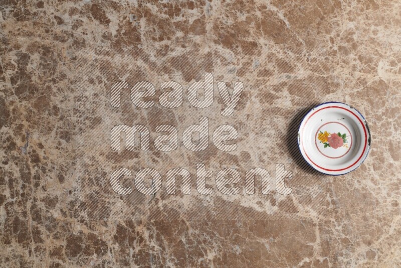 A vintage metal plate on beige marble background