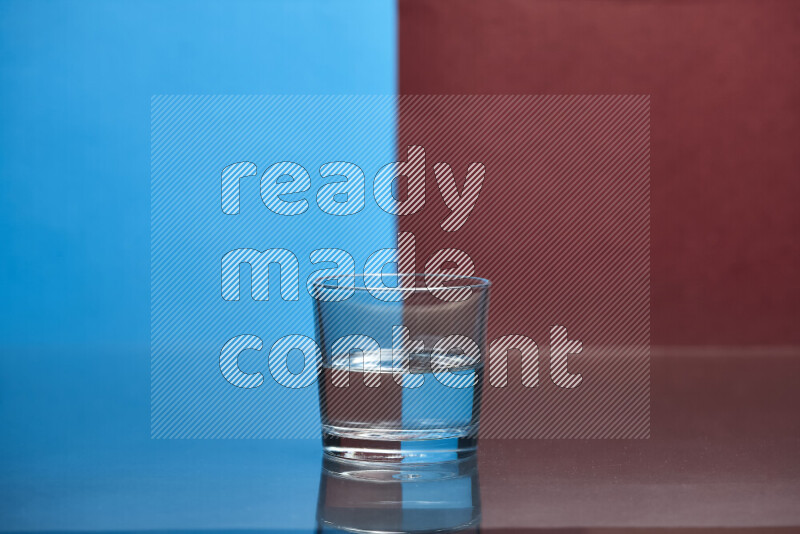 The image features a clear glassware filled with water, set against blue and dark red background