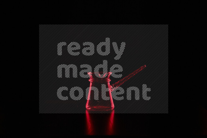 Glassware with rim light in red against black background