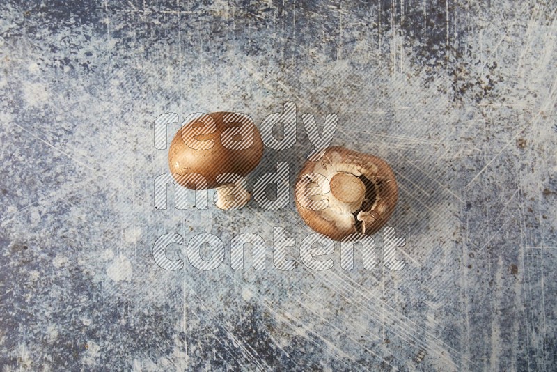 small fresh Cremini wood mushrooms topview on blue textured background