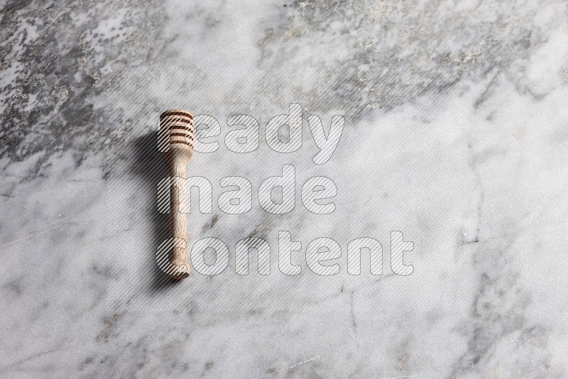 Wooden honey handle on grey marble flooring, 65 degree angle