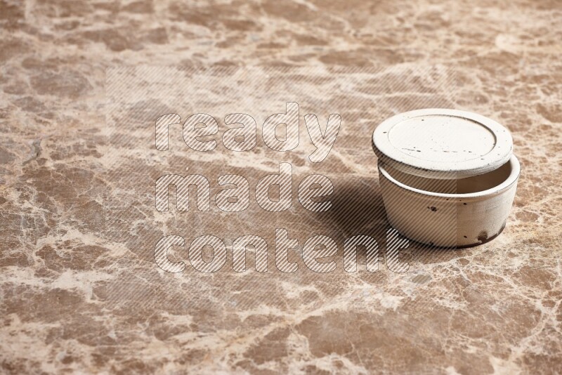 A white pottery bowl on beige marble background