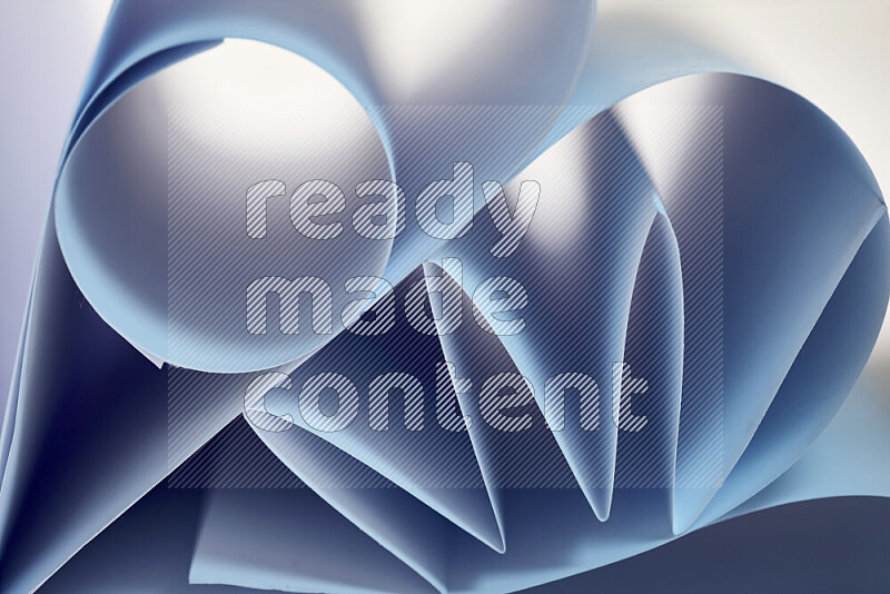 عرض فني لطيات الورق تخلق مزيج من الأشكال الهندسية، مضاءة بإضاءة ناعمة بدرجات اللون الأزرق