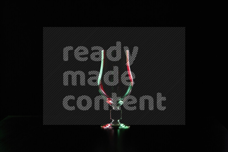 Glassware with rim light in red and green against black background