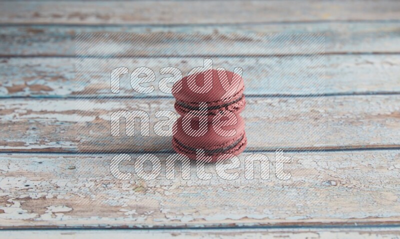 45º Shot of two Red Cherry macarons on light blue wooden background