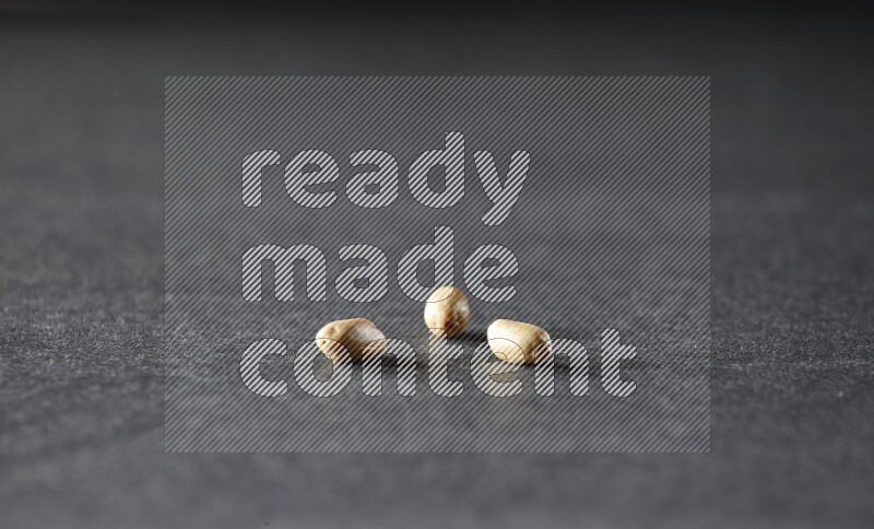 3 حبات من الفول السوداني المقشر علي خلفية سوداء