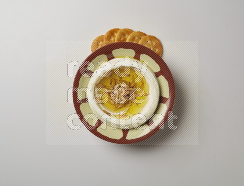 Lebnah garnished with pine nuts in a traditional plate on a white background