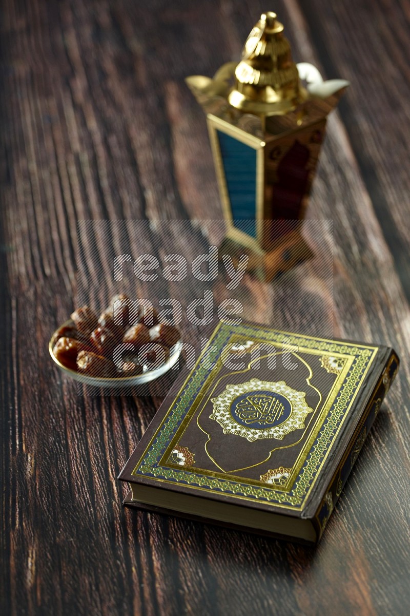 A golden lantern with different drinks, dates, nuts, prayer beads and quran on brown wooden background