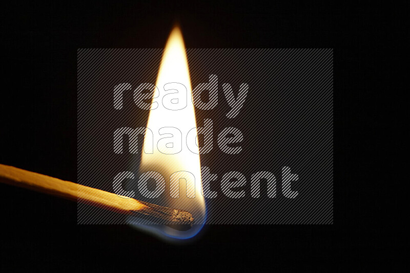 A burning matchstick isolated on dark backdrop