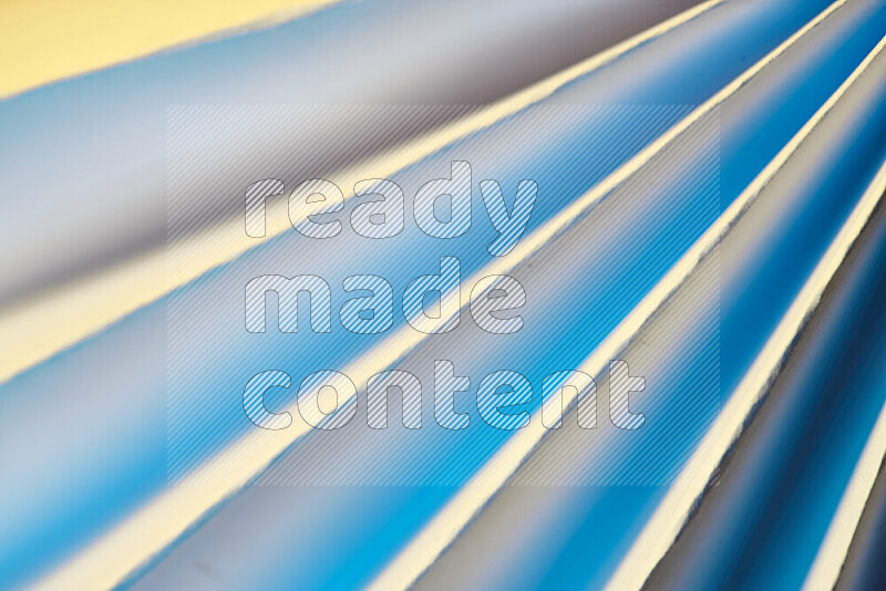 An image presenting an abstract paper pattern of lines in blue and gold tones