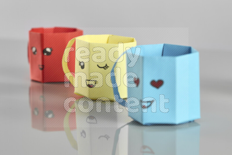 Origami cup on grey background