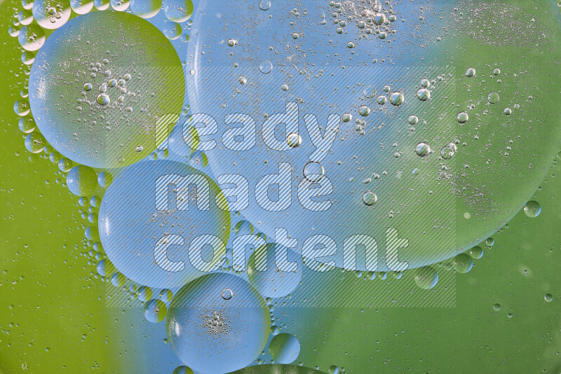 Close-ups of abstract oil bubbles on water surface in shades of green and blue