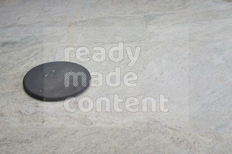 A flat pottery plate on grey marble background
