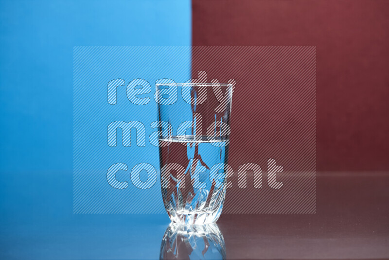 The image features a clear glassware filled with water, set against blue and dark red background