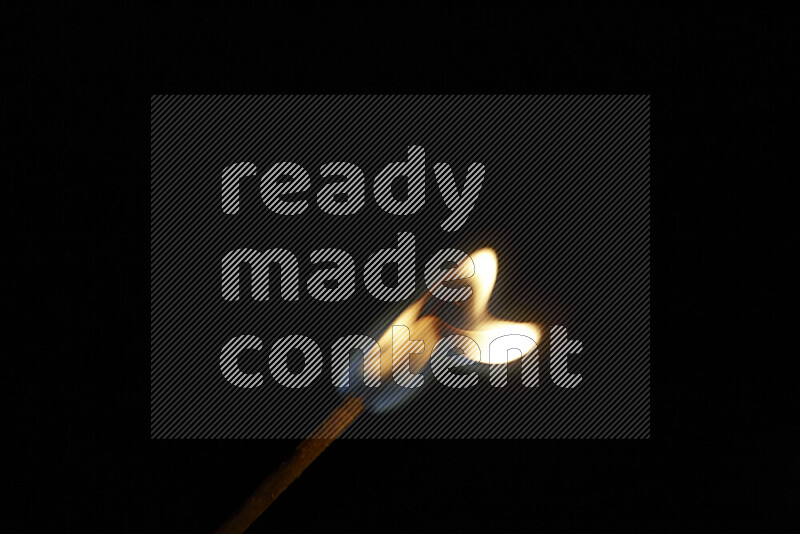 A burning matchstick isolated on dark backdrop