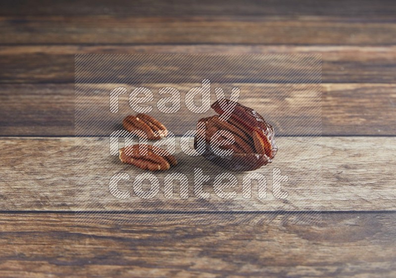 pecan stuffed madjoul date on a wooden background