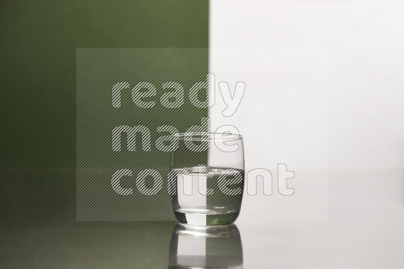 The image features a clear glassware filled with water, set against white and dark green background