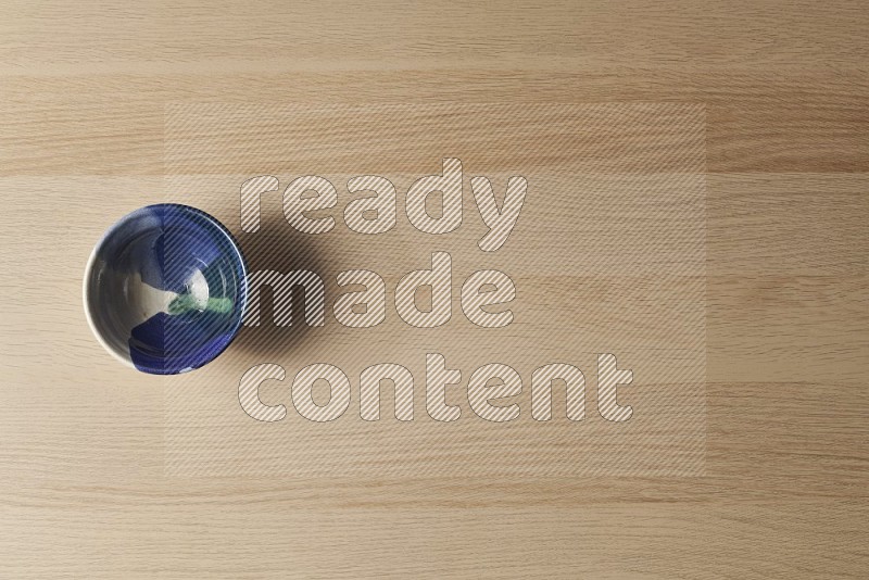 Top View Shot Of A Multicolored Pottery Bowl on Oak Wooden Flooring