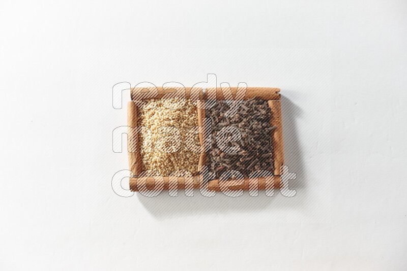 2 squares of cinnamon sticks full of cloves and sesame on white flooring