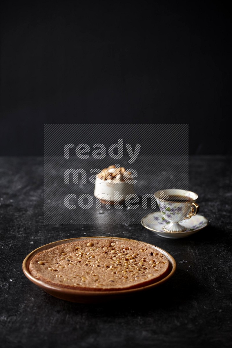 Basbousa with nuts and tea in a dark setup