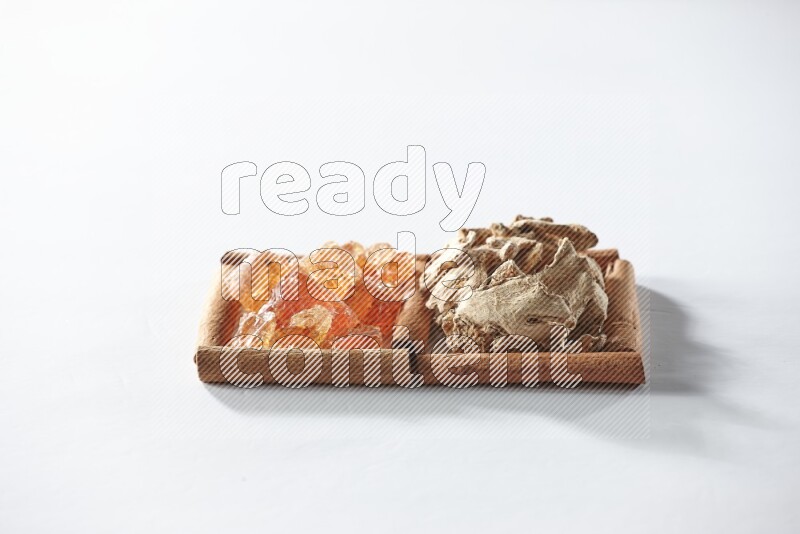 مربعان من أعواد القرفة ممتلئان بالزنجبيل المجفف والصمغ العربي علي خلفية بيضاء