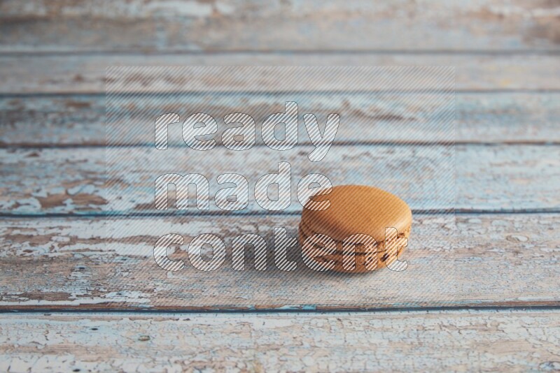 45º Shot of Brown Maple Taffy macaron on light blue wooden background