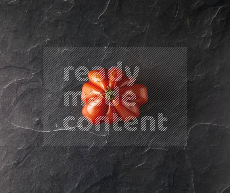 Single Topview Heirloom tomato on a black slate background
