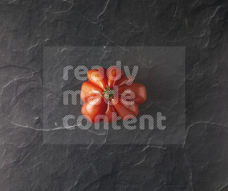 Single Topview Heirloom tomato on a black slate background