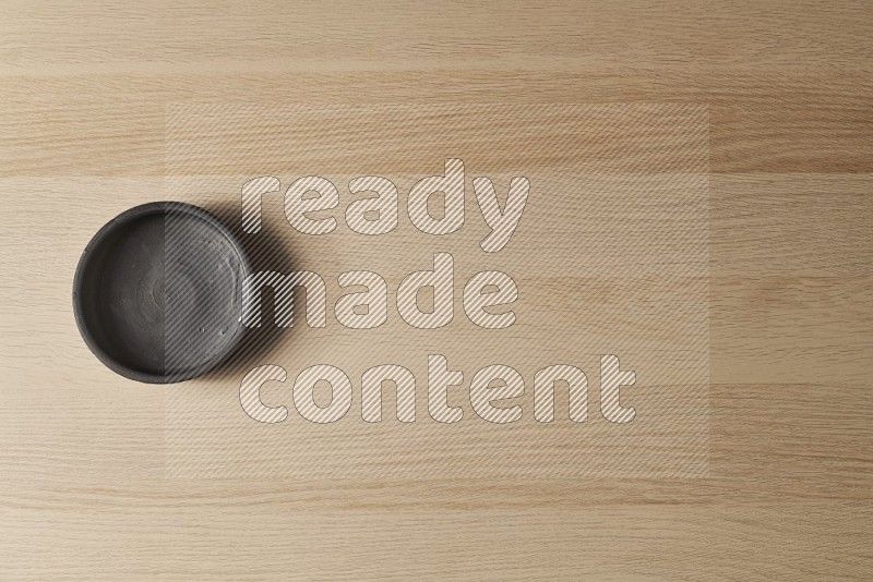 Top View Shot Of A Black Pottery Bowl on Oak Wooden Flooring