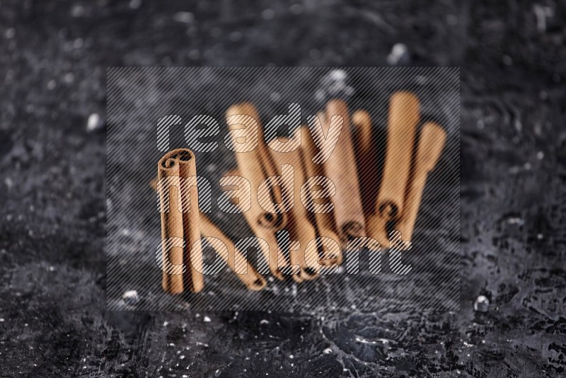 Cinnamon sticks on a textured black background