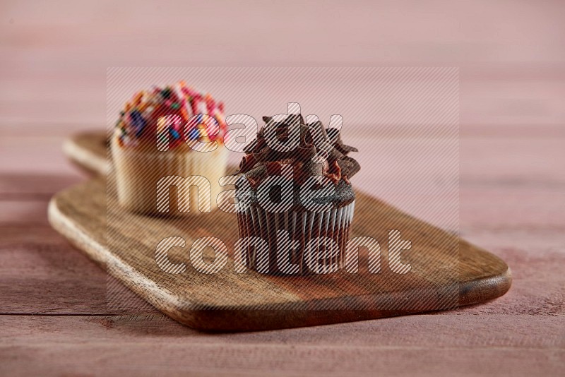 Chocolate mini cupcake topped with chocolate curls on a wooden board