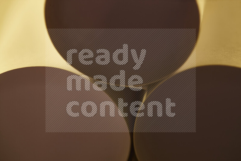 The image shows an abstract paper art with circular shapes in varying shades of gold