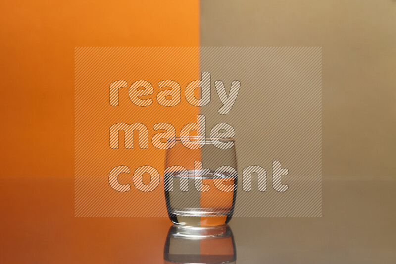 The image features a clear glassware filled with water, set against orange and beige background