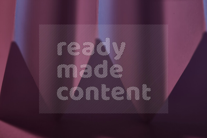 صورة مجردة مقربة تظهر طيات ورقية هندسية حادة بتدرجات اللون الارجواني