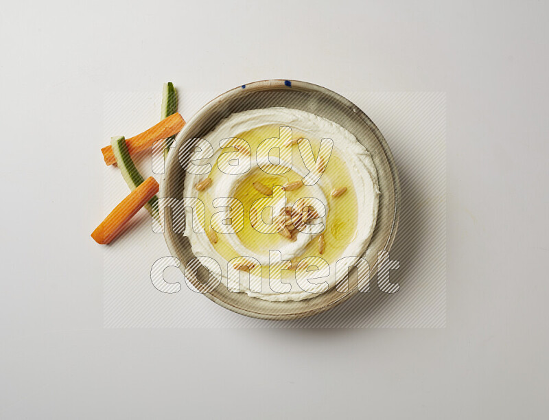 Lebnah garnished with pine nuts in a grey pottery plate on a white background