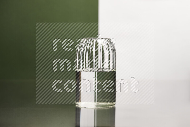 The image features a clear glassware filled with water, set against white and dark green background