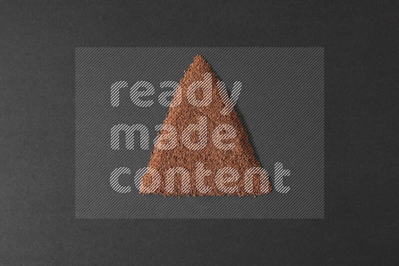 Garden cress seeds in a triangle shape on a black flooring