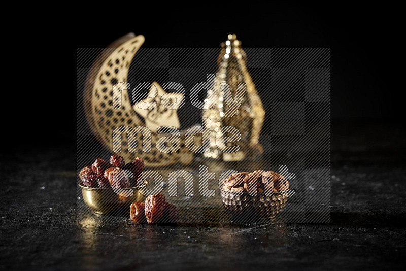 Dates in a metal bowl with almonds beside golden lanterns in a dark setup