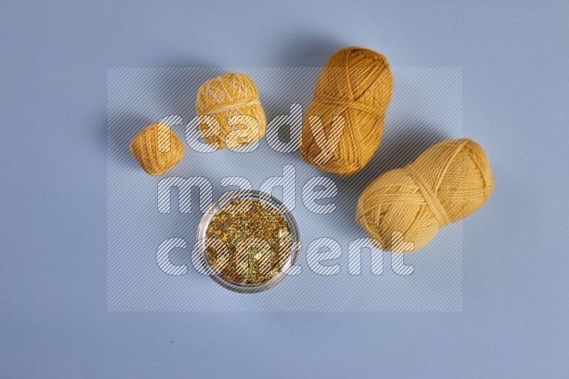 A yellow collection of sewing and tailoring tools arranged on a blue background