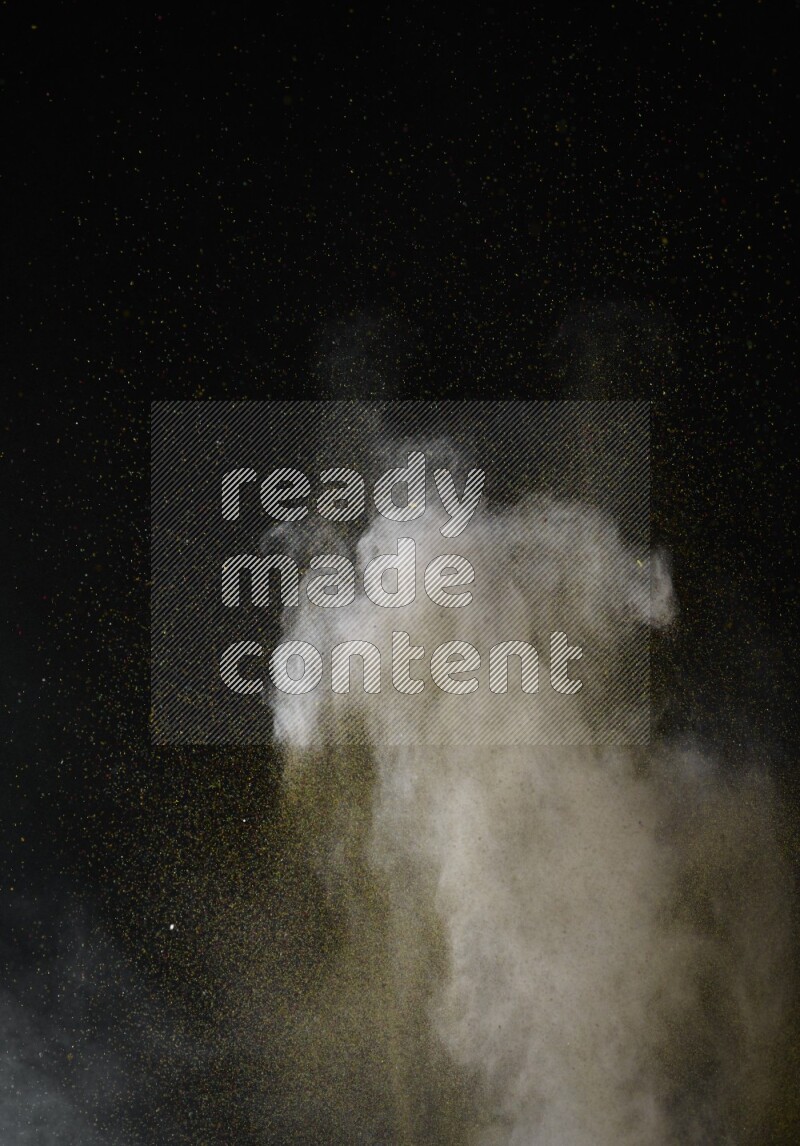 A side view of brown powder explosion on black background