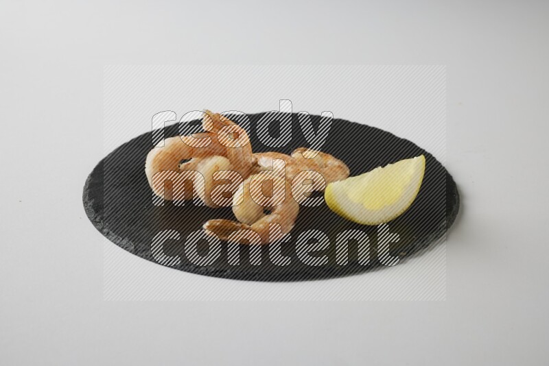 five grilled shrimps  on a black slate direct  on a white back ground