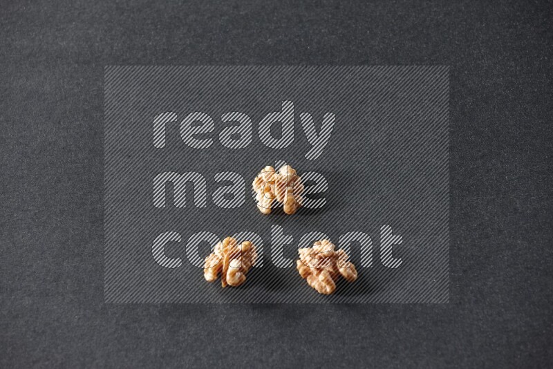 3 walnuts on a black background in different angles