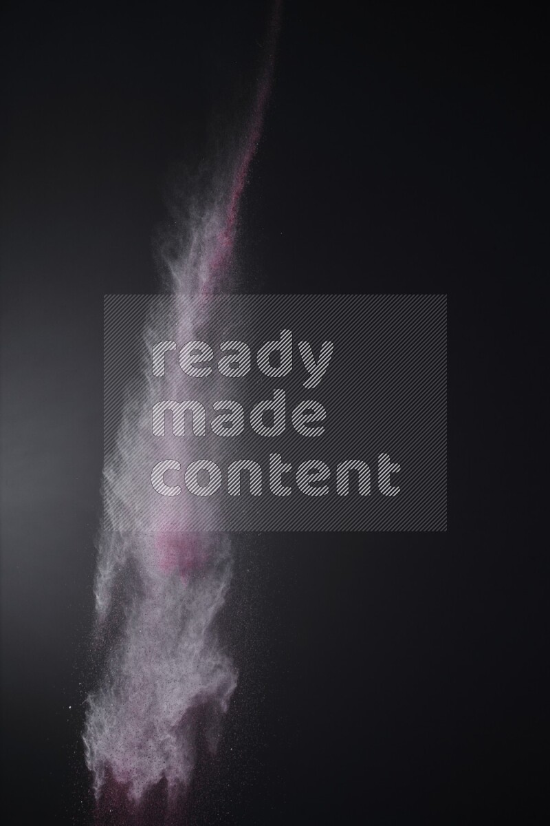 A side view of red powder explosion on black background
