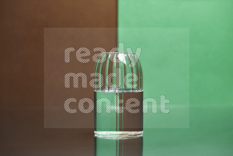 The image features a clear glassware filled with water, set against brown and green background