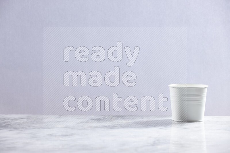An empty white plant pot on grey marble background